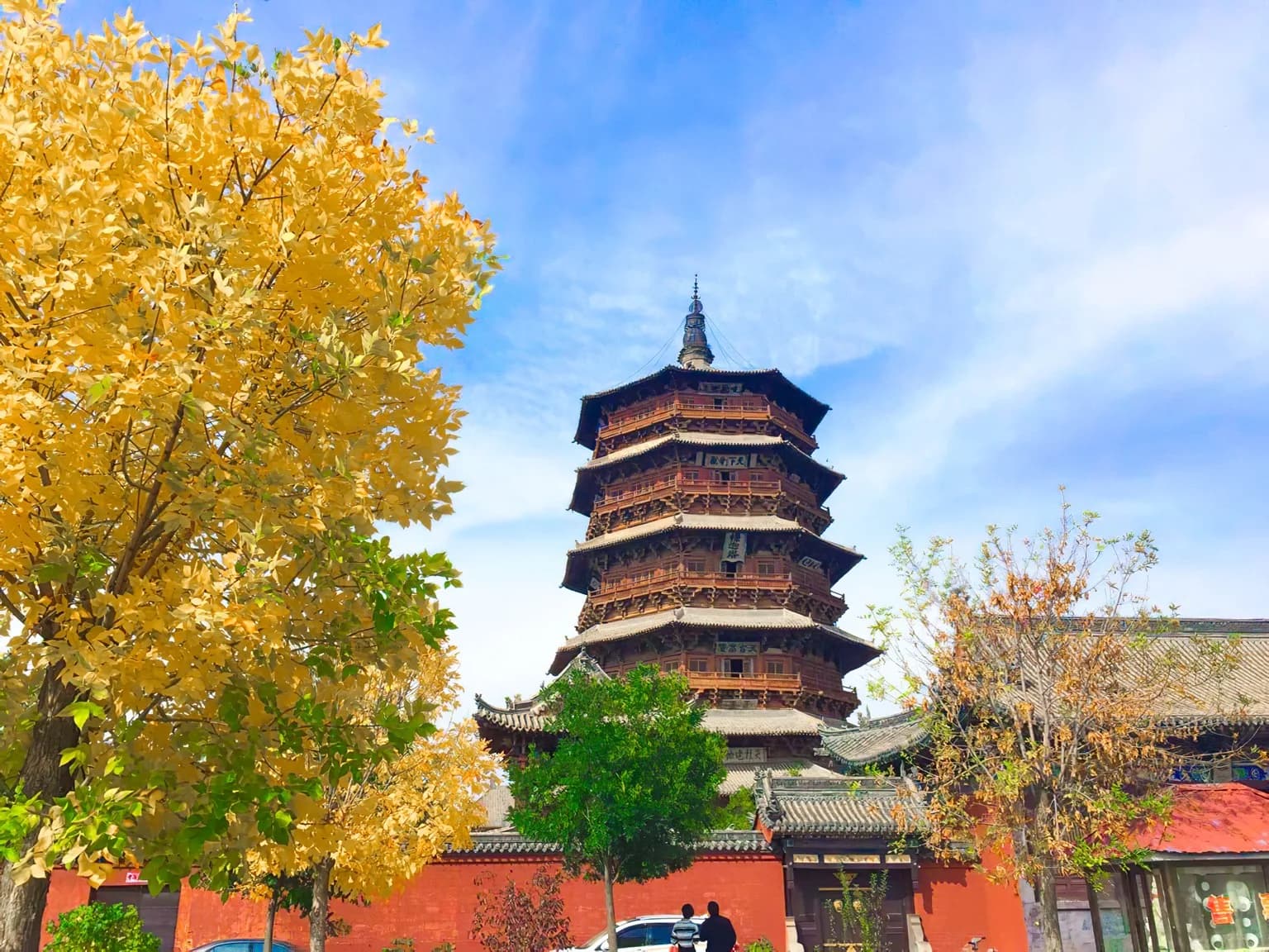 Yingxian Wooden Pagoda framed by autumn trees and red temple walls