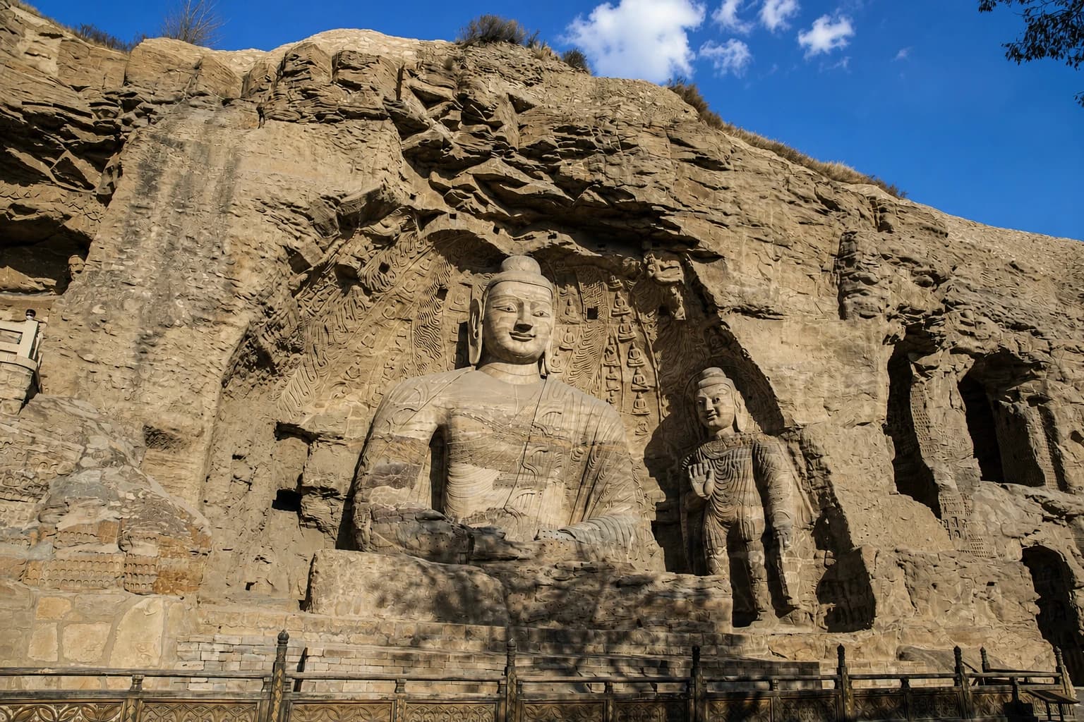 Monumental Buddhist figures carved into the sandstone cliff at Yungang Grottoes